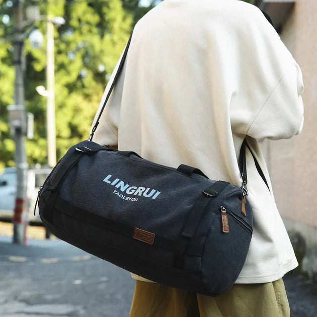 Person carrying a black bag with 'LINGRUI' branding on a blurred street background