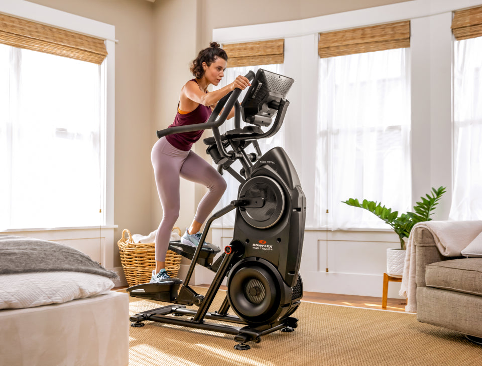 Woman exercising on aelliptical machine in a home setting